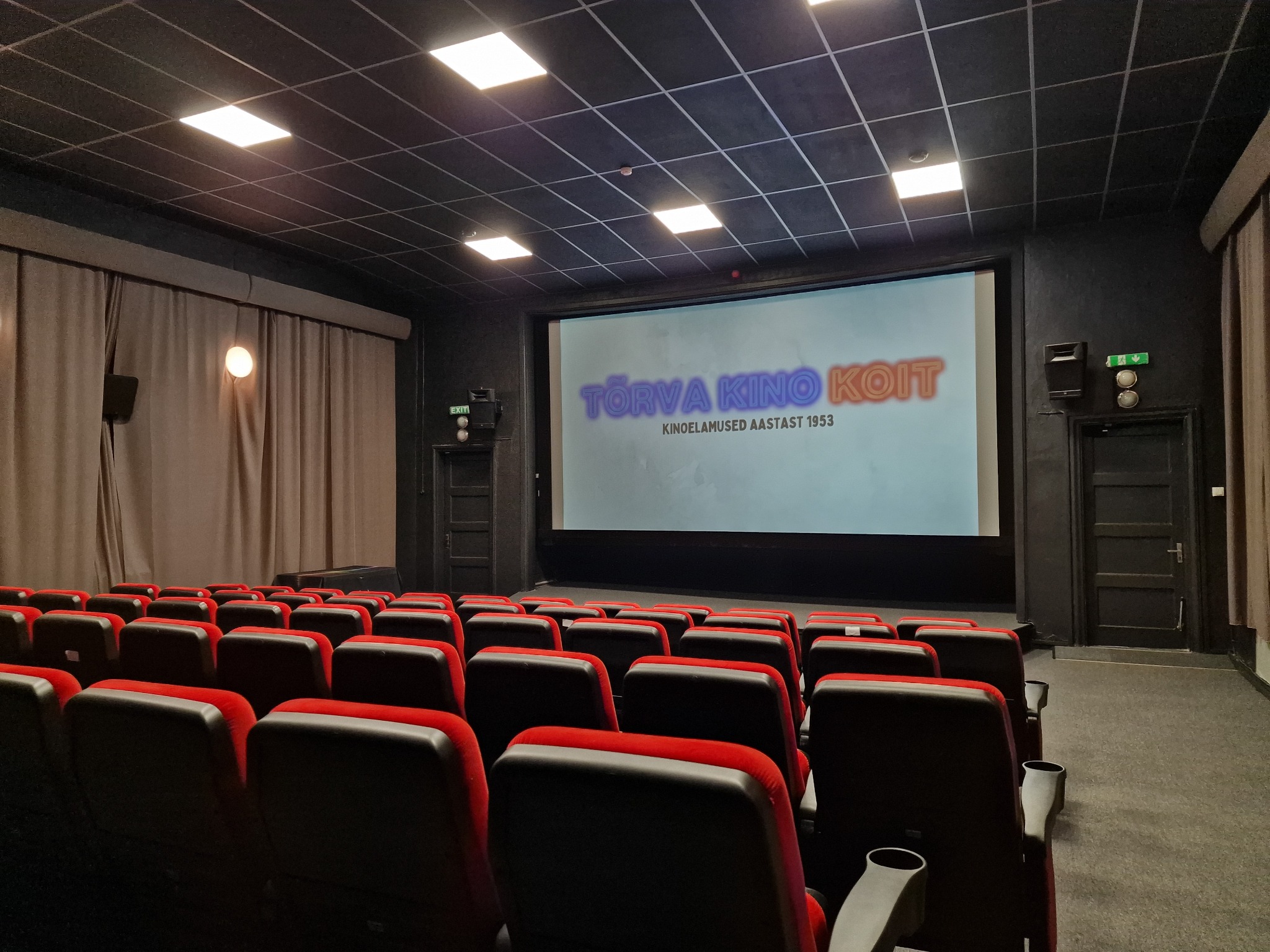 Tõrva kino Koit saal punaste toolide ja kinolinaga